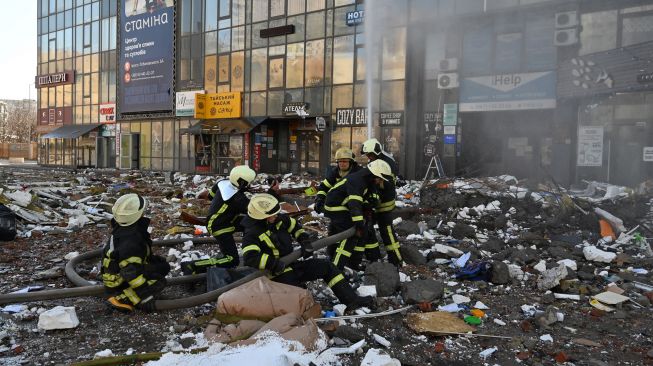 Petugas pemadam kebakaran memadamkan api di blok apartemen yang terkena rudal serangan militer Rusia di Kyiv, Ukraina, Sabtu (26/2/2022). [GENYA SAVILOV / AFP]