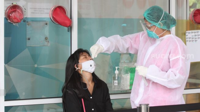 Petugas kesehatan melakukan swab PCR kepada warga di kawasan Cilandak, Jakarta Selatan, Selasa (31/5/2022). [Cariberita.co.id/Alfian Winanto]